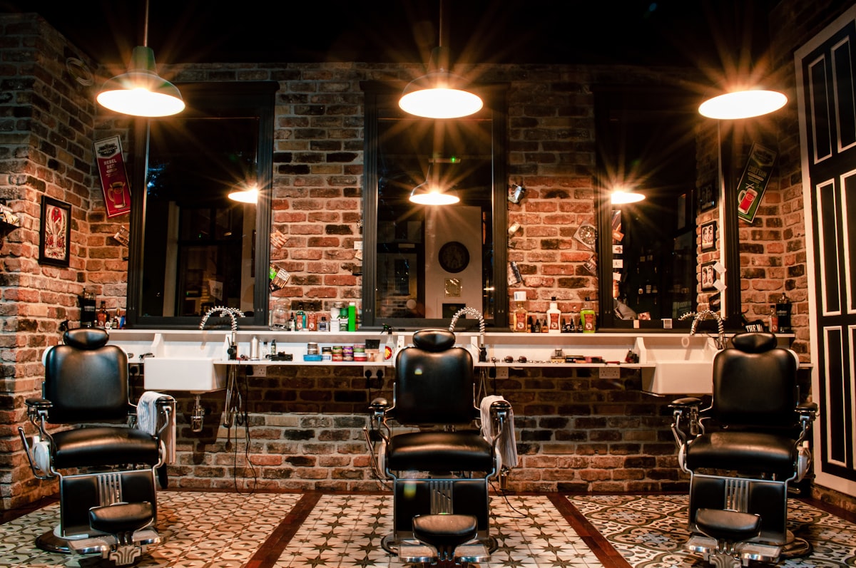 Interior de barbearia com cadeiras clássicas e luz quente