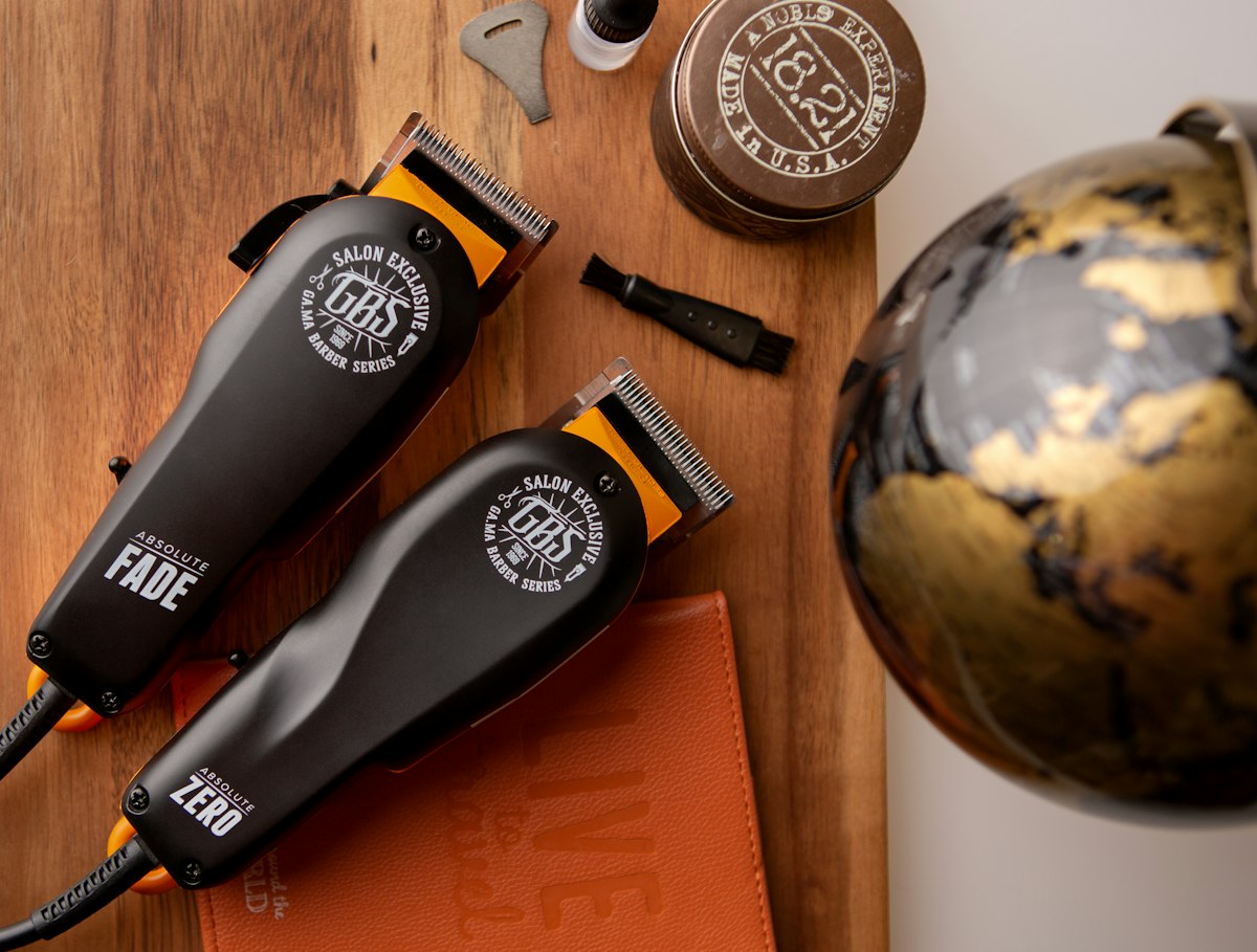 Duas máquinas de cortar cabelo sobre uma mesa de madeira