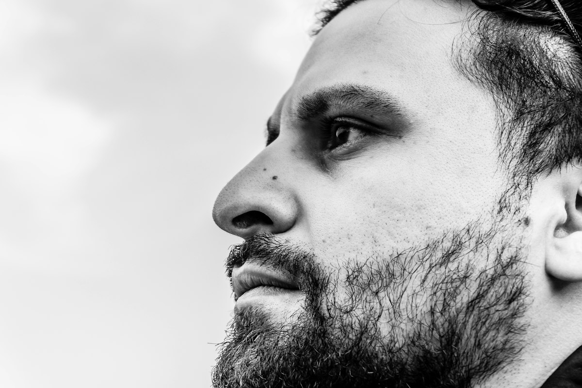 Perfil a preto e branco de um homem com barba curta