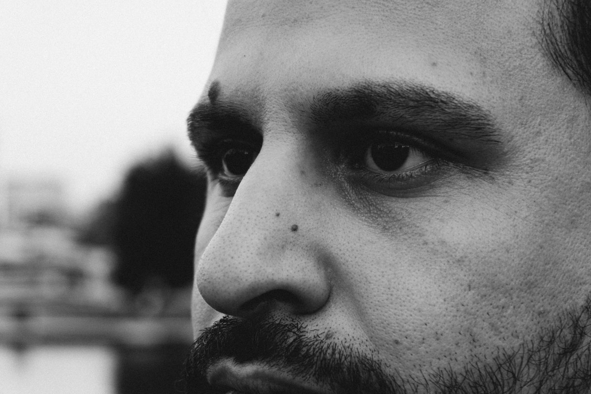 Grande plano a preto e branco de um rosto masculino de perfil, com o nariz em destaque